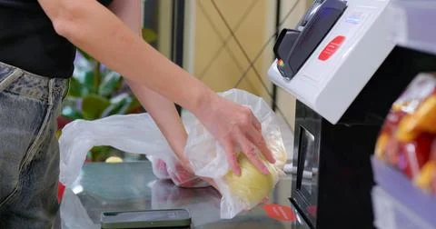 Customer scans packaged apple at self-checkout terminal in grocery store. 库存照片