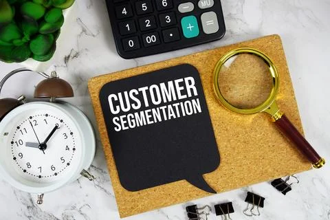 Customer Segmentation text with Calculator, alarm clock and magnifying glas.. Stock Photos