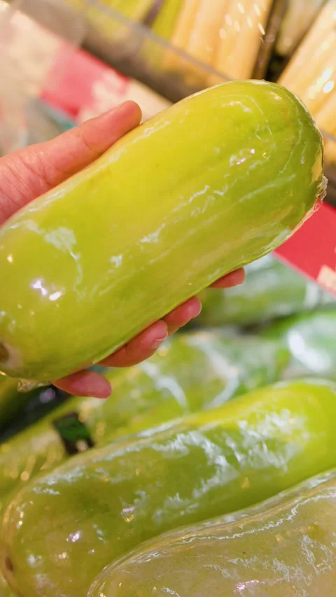 Customer Selecting Fresh Green Papaya in a Supermarket Produce Section Stock Footage 341928532