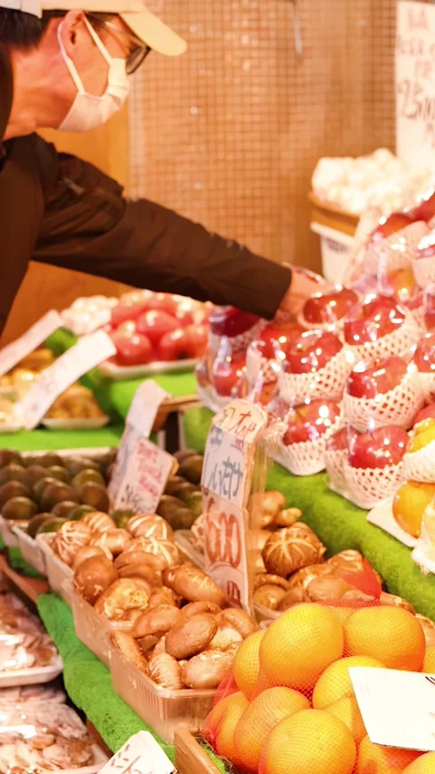 Customer Selecting Fresh Red Apples at a Tokyo Street Market 库存影片 343841765