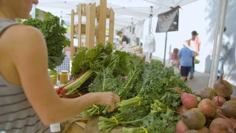 Customer selecting leafy vegetable at street market Stock Footage 87808570