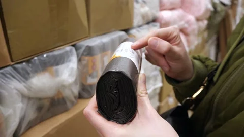 The customer selects and reads the description of garbage bags Stock Footage 269409771