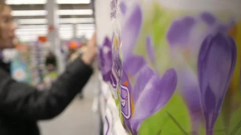 A customer selects and takes packages of toilet paper from a store shelf. Stock Footage 300111624