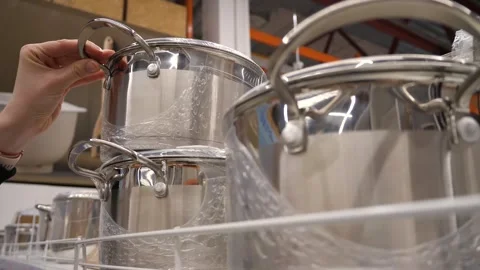 A customer selects and takes a pan from a shelf in a store. Stock Footage 270486132