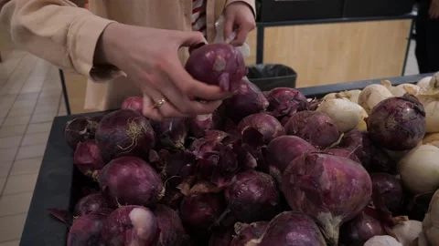 A customer selects a red onion in a store. Vídeo Stock 310903269