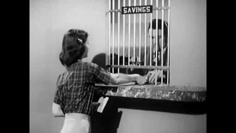 A customer is served by a teller at a savings window and customers are served by Stock Footage 89579560