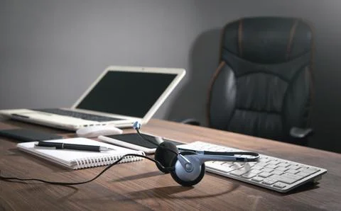 Customer service headset, computer keyboard and business objects on the blu.. Stock Photos
