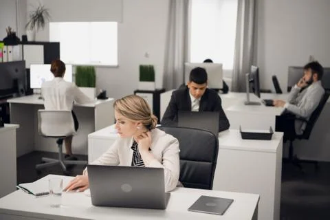 Customer service Manager at the workplace at the table with a laptop. Stock Photos
