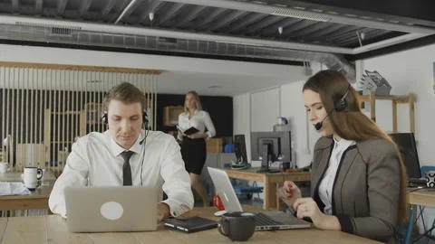 Customer service operators taking calls in busy call center, manager check their Stock Footage 108626760