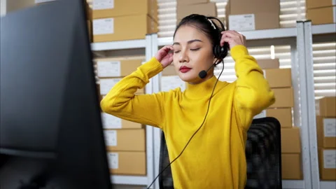 Customer service representative wearing headset working at computer Video stock 326275232