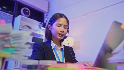 Customer service representative wearing microphone headset and working on laptop Video stock 335804788