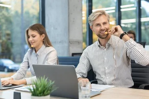Customer service representatives engaged in professional work using headsets  Stock Photos