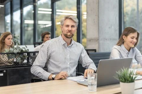 Customer service representatives engaged in professional work using headset.. Stock Photos