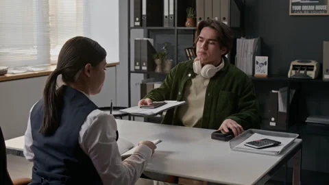Customer Sitting Down and Handing his Passport and Documents to Bank Worker Stock Footage 330959138