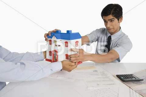 Customer snatching a model home from a real estate agent Stock Photos