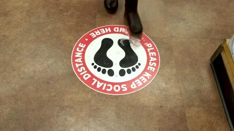 A customer is standing on a social distancing floor sticker in grocery Stock Footage 145500755
