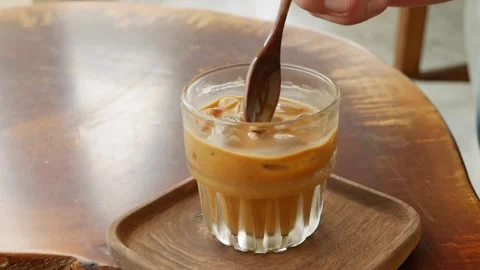 Customer stirring and drinks coffee with milk. Vietnamese Traditional phin Stock Footage 136174091