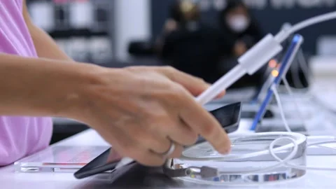 Customer in store selects tablet from models on customer shelf. Modern woman Stock Footage 257667240