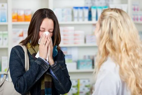 Customer suffering from cold with pharmacist in foreground Stock Photos