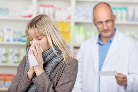 Customer suffering from cold with pharmacist reading prescriptio Foto stock