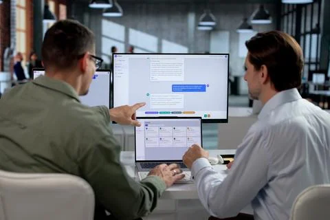 Customer Support Agents Discussing AI Chatbot Platform Improvements Using Lap Stock Photos