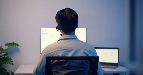 Customer Support Call Center Agent With Headset Working On Computer At Night. Stock Footage 322571343