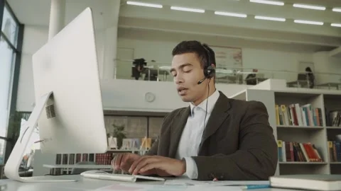 Customer support operator with hands-free headset working in the office, mixed Stock Footage 143212228