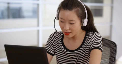Customer support phone operator communicating using headset and laptop computer Stock Footage 87674033