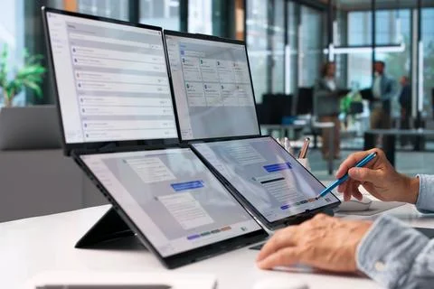 Customer Support Specialist Multitasks On Foldable Laptop Using AI Chatbot Pl Stock Photos