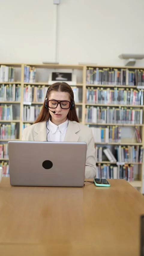 Customer support specialist talks to client through headset while using laptop Stock-Footage 342179017