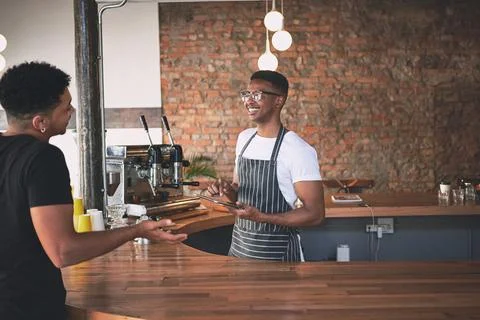 Customer, tablet and men in coffee shop at counter for service with drink, .. Stock Photos