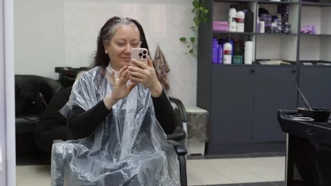 Customer taking selfie while dyeing hair at salon Vídeo Stock 307469167