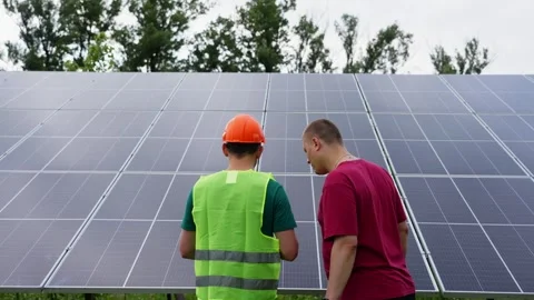 A customer is talking to an engineer in front of solar panels. Video stock 314797678