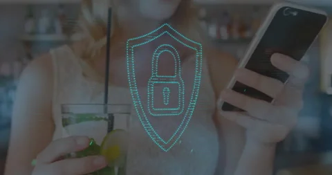 Customer tapping phone for secure payment while shield graphic pulsing beside Stockbeeldmateriaal 312348588