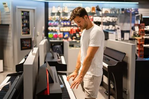 Customer testing electronic piano in store Stock Photos
