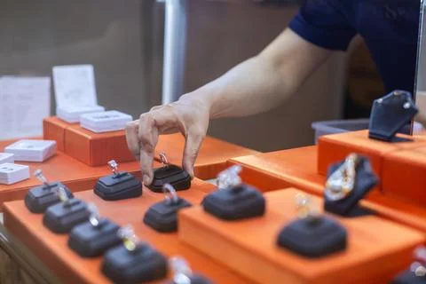Customer Touching Diamond Ring Displayed on Showcase Counter in Jewelry Store Stock Photos