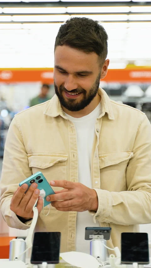 Customer trying out new smartphone in electronics store Stock Footage 317735655