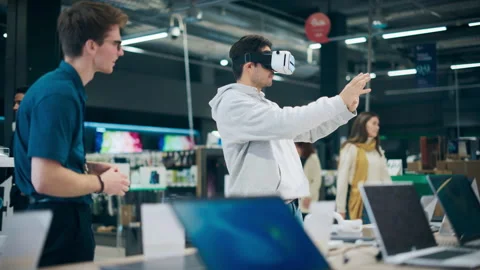 Customer Trying Out Virtual Reality Headset in Store Stock Footage 243831244