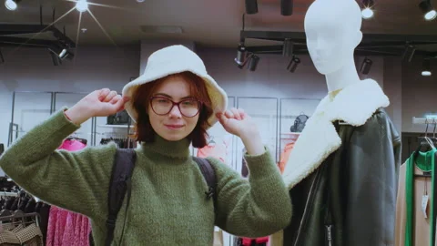 Customer trying on white bucket hat in clothing store Video stock 311333340