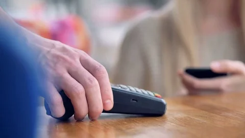 Customer uses smartphone to make a wireless payment. Stock Footage 82393922