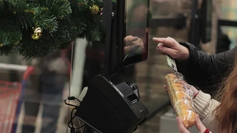 Customer uses touch panel at self-service checkout ACO. Buyer manually enters Video stock 219412180