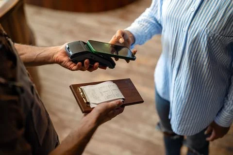Customer using cashless mobile payment technology for a quick bill transact.. Stock Photos