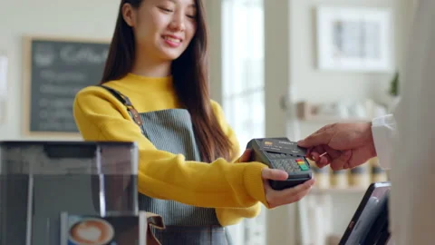 Customer using credit card for payment to owner at cafe restaurant Stock Footage 196902492