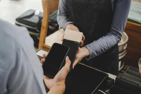 Customer using digital mobile phone scan bar code pay for buying coffee Stock Photos