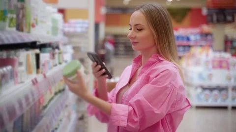 Customer using smartphone scanning product in supermarket 스톡 동영상 311983627