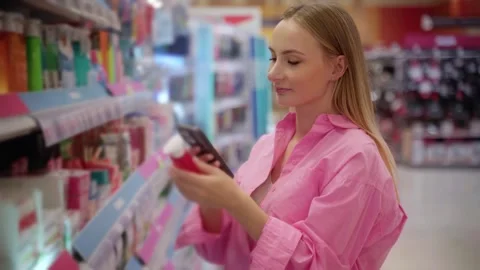 Customer using smartphone scanning product in supermarket Stock Footage 311983984