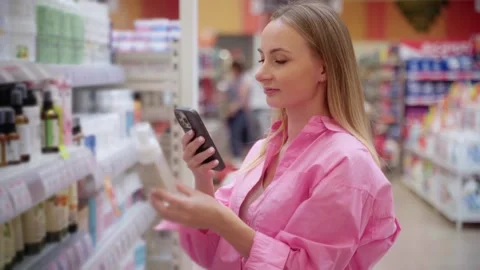 Customer using smartphone scanning product in supermarket Stock Footage 311984045
