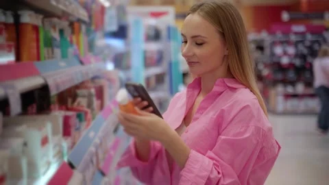 Customer using smartphone scanning product in supermarket Stock Footage 311984228