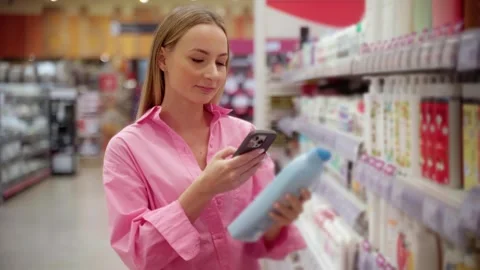 Customer using smartphone scanning products in supermarket Stock Footage 311983961