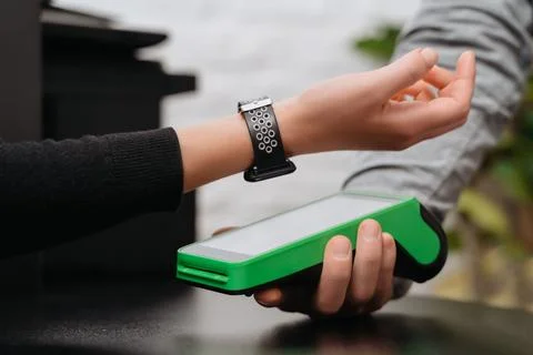 Customer using smartwatch for contactless payment via nfc terminal Stock Photos